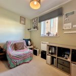 Cosy home office with sofa and bookshelf.