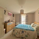 Cosy bedroom with blue crochet blanket on bed.