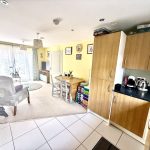 Open-plan kitchen and lounge with dining table.