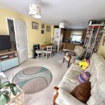 Cosy living room with TV, sofa, and dining area.