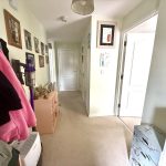 Bright hallway with coat rack and artwork.