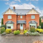 Two-storey red brick house with driveway.