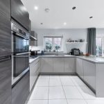 Modern kitchen with grey cabinets and appliances.