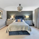 Modern bedroom with blue bed and elegant decor.
