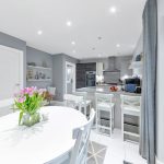 Modern kitchen with white dining table and flowers