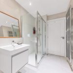 Modern bathroom with shower and vanity unit.