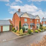 Modern red-brick house with garden and garage.