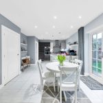 Modern kitchen with table and garden view.
