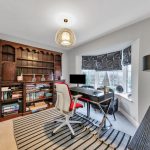 Home office with desk, chair, and bookshelves.