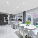 Modern kitchen with white dining table and chairs.