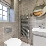 Modern bathroom with sink, toilet, and heated towel rail.