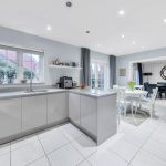 Modern kitchen with dining area and tiled flooring.