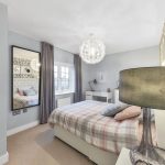 Modern bedroom with stylish decor and large mirror.