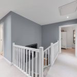 Modern hallway with blue walls and white railings