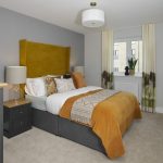 Modern bedroom with grey and mustard decor.