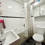 Modern bathroom with sink, bathtub, and toilet.