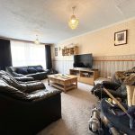 Cosy living room with sofas and TV unit.