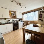 Modern kitchen with dining table and appliances.