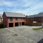 Modern residential area with parking spaces, sunny day.