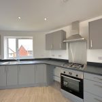 Modern kitchen with grey cabinets and gas hob.