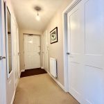 Modern hallway with light fixture and white doors.