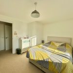 Bright bedroom with modern decor and large bed.