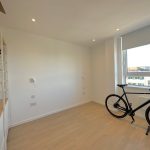 Modern room with shelves and bike by window.