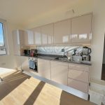 Modern kitchen with appliances and sunlight through window.