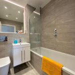 Modern bathroom with bathtub and yellow towel