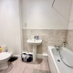 Modern bathroom with toilet, sink, and bathtub.
