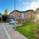 Modern brick building with parked silver car