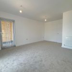Empty room with carpet, white walls, and doorway