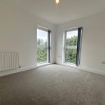Bright carpeted room with large windows.
