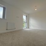 Bright empty room with carpet and radiator.
