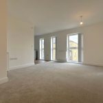 Spacious empty living room with large windows.
