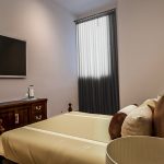 Modern bedroom with TV and wooden furniture