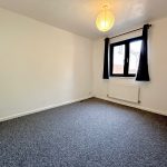 Empty room with window and grey carpet