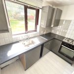 Modern kitchen with appliances and garden view.