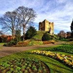 Historic castle with vibrant gardens in spring.