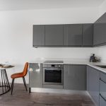 Modern grey kitchen with dining area and chairs