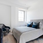 Modern bedroom with window and stylish furnishings.