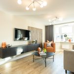 Modern living room with TV and cosy seating.
