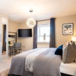 Modern bedroom with elegant decor and large window.