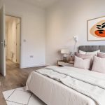Modern bedroom with plant and abstract art.