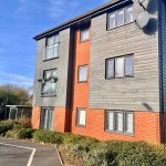 Modern apartment building with brick and wood exterior.