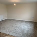 Empty room with grey carpet and white walls.