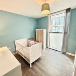 Modern nursery with cot and blue walls.