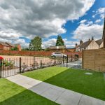 Brick houses and garden under cloudy sky
