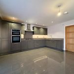 Modern kitchen with grey cabinets and built-in appliances.
