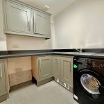 Modern utility room with cabinets and washing machine.